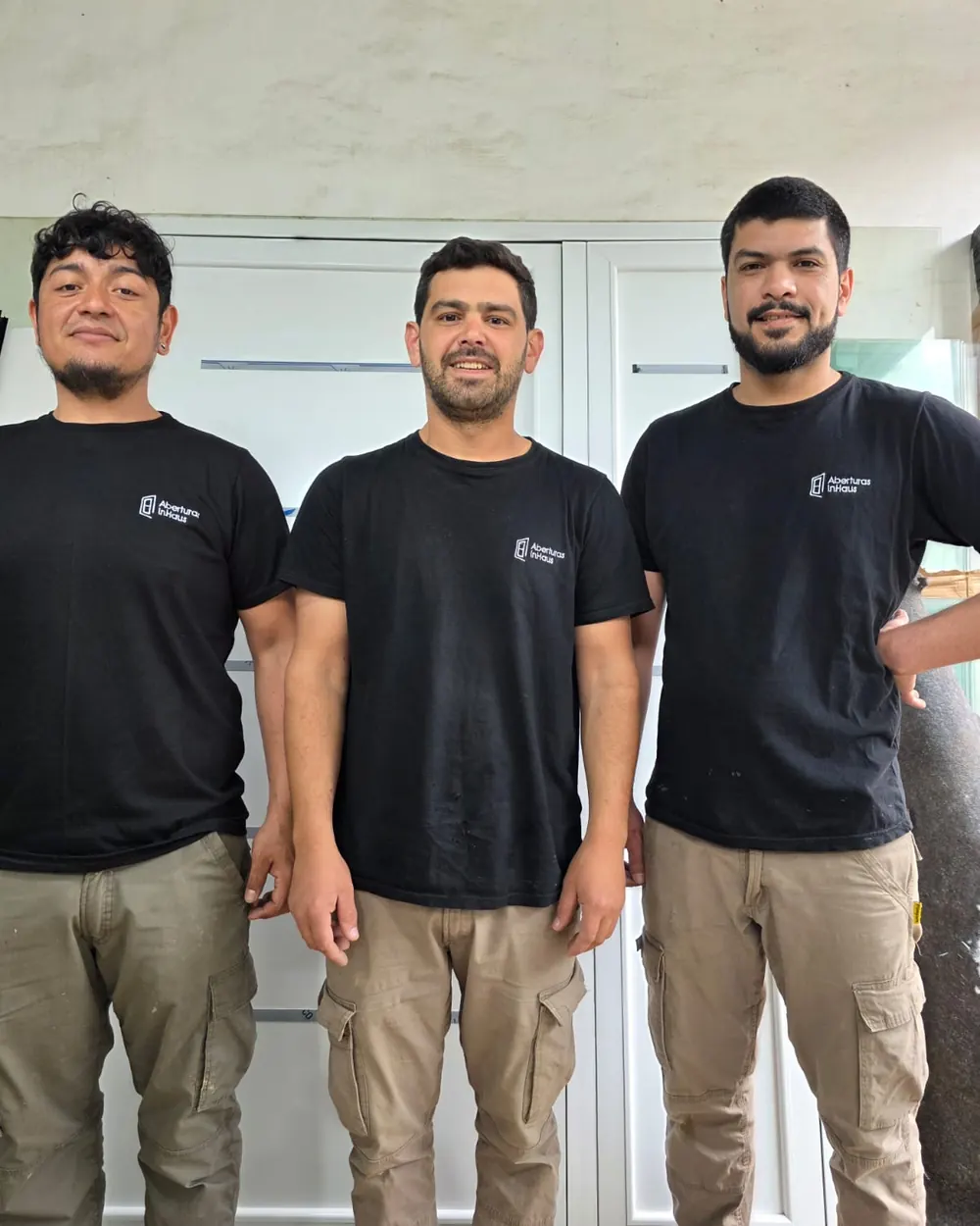 Lautaro, en el medio, con Gustavo y Checho, armadores y colocadores de InHaus, en el taller con la remera de la marca