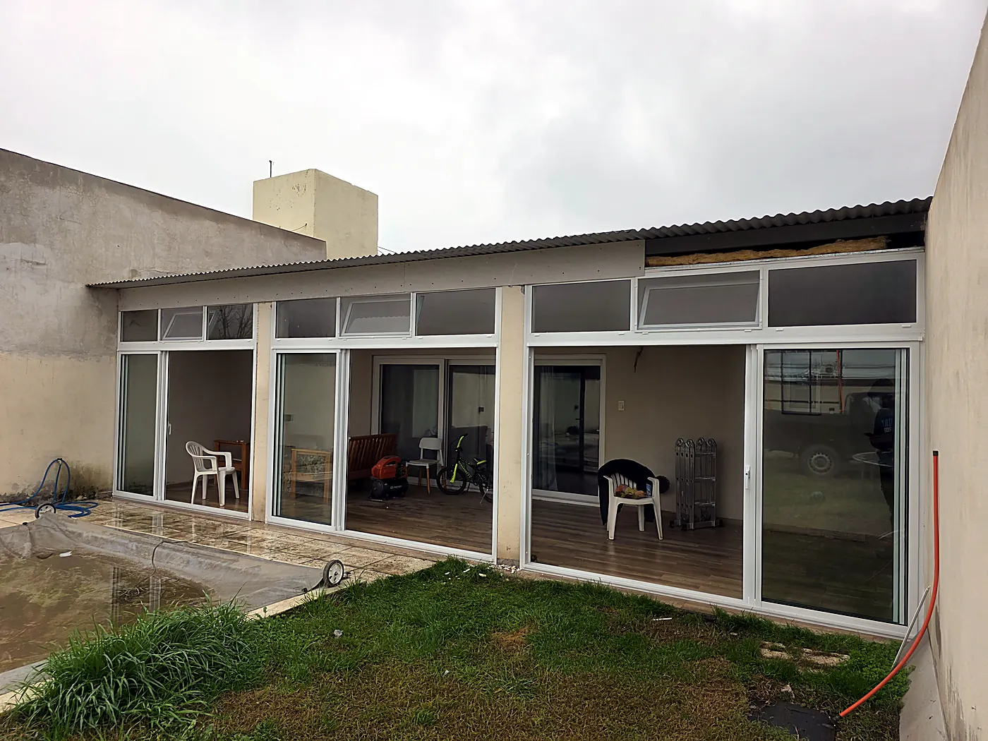 Cerramiento de galería de aluminio blanco frente a una pileta